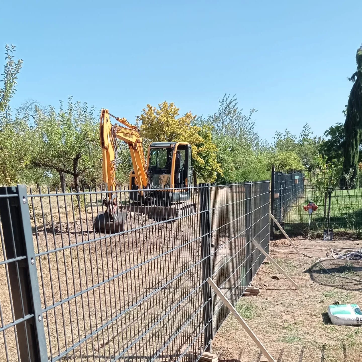 Zaun-Baustelle mit Bagger